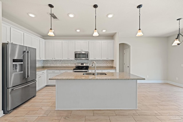 12789 Island Spirit Dr, Pensacola, FL 32506 - kitchen featuring arched walkways, a sink, appliances with stainless steel finishes, and tasteful backsplash