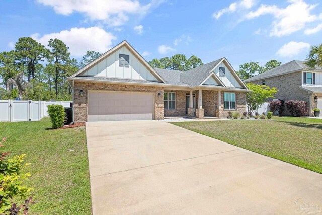 12789 Island Spirit Dr, Pensacola, FL 32506 - craftsman house featuring a front lawn, driveway, board and batten siding, and a garage