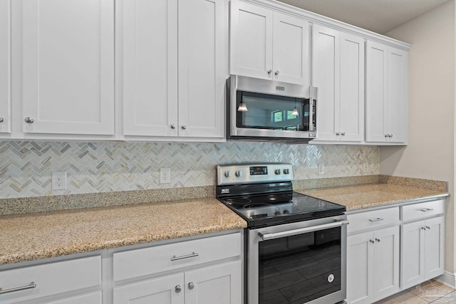 12789 Island Spirit Dr, Pensacola, FL 32506 - kitchen featuring decorative backsplash, white cabinetry, and appliances with stainless steel finishes