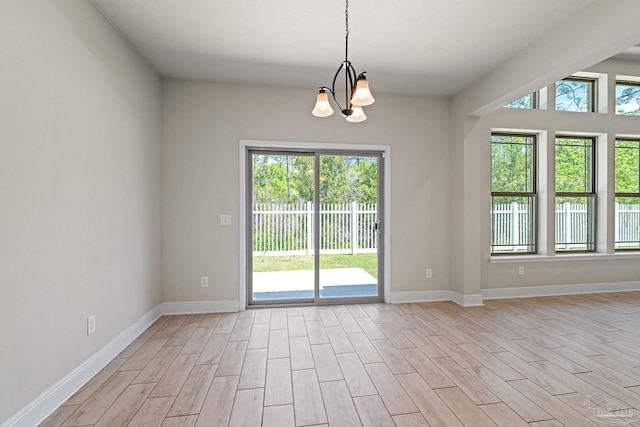 12789 Island Spirit Dr, Pensacola, FL 32506 - spare room featuring light wood-style floors, baseboards, and an inviting chandelier