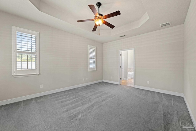 12789 Island Spirit Dr, Pensacola, FL 32506 - carpeted empty room with a tray ceiling, visible vents, a ceiling fan, and baseboards