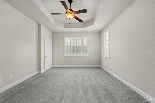 12789 Island Spirit Dr, Pensacola, FL 32506 - spare room with a ceiling fan, baseboards, carpet floors, and a tray ceiling