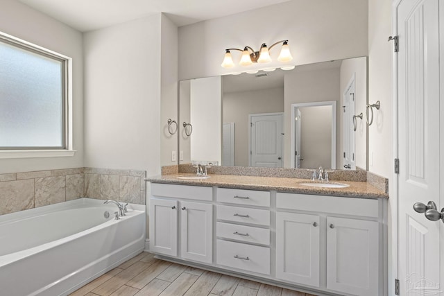 12789 Island Spirit Dr, Pensacola, FL 32506 - full bath featuring double vanity, a garden tub, wood finished floors, and a sink