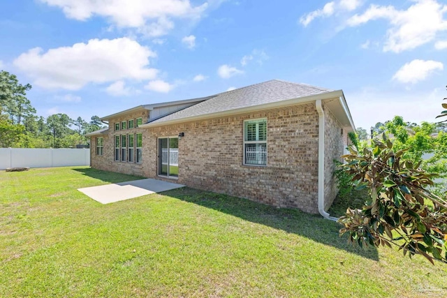 12789 Island Spirit Dr, Pensacola, FL 32506 - back of property with fence, a shingled roof, brick siding, and a yard