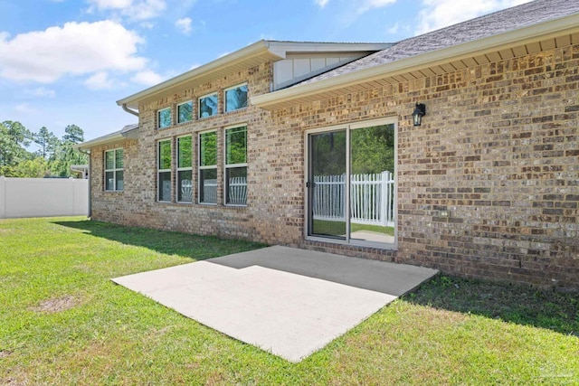 12789 Island Spirit Dr, Pensacola, FL 32506 - back of property with fence, brick siding, a lawn, board and batten siding, and a patio