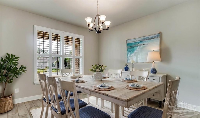 12789 Island Spirit Dr, Pensacola, FL 32506 - dining room featuring light wood-type flooring, baseboards, and a notable chandelier