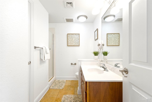 bathroom featuring tile patterned floors, vanity, a shower with shower door, and toilet