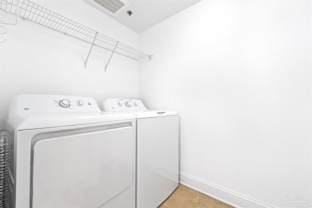 laundry area featuring separate washer and dryer and light tile patterned floors