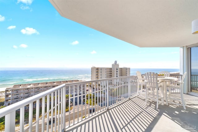 balcony featuring a beach view and a water view