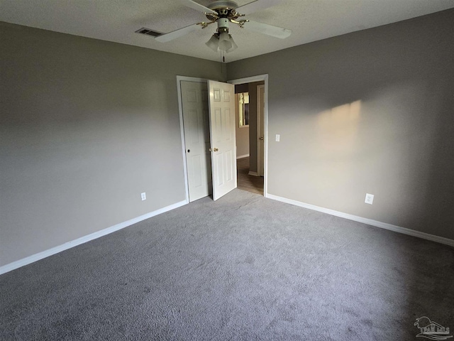 unfurnished bedroom featuring carpet floors, baseboards, ceiling fan, and visible vents