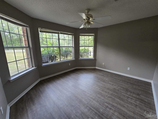 empty room featuring plenty of natural light, a ceiling fan, and a textured ceiling