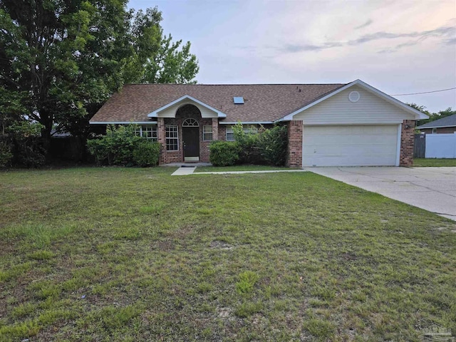 single story home featuring a front yard, an attached garage, brick siding, and driveway