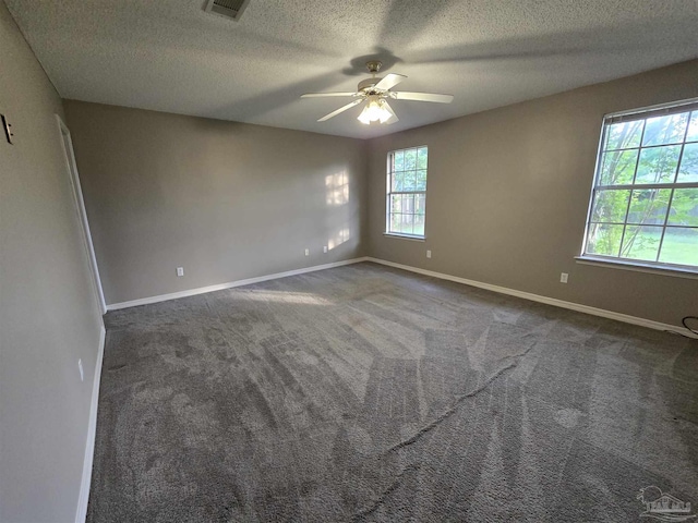 spare room featuring a textured ceiling, visible vents, carpet flooring, a ceiling fan, and baseboards