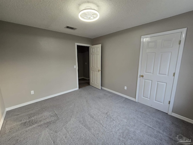 unfurnished bedroom with carpet, baseboards, visible vents, and a textured ceiling