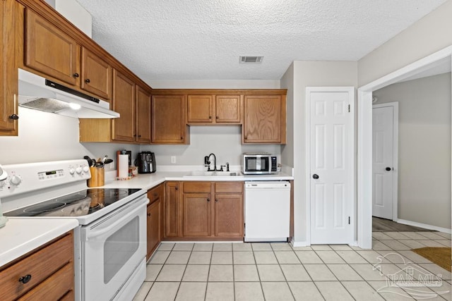 4546 Northpointe Pl, Pensacola, FL 32514 - kitchen featuring white appliances, under cabinet range hood, a sink, brown cabinets, and a textured ceiling
