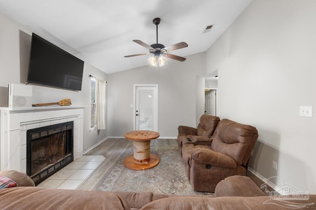 4546 Northpointe Pl, Pensacola, FL 32514 - living room with vaulted ceiling, light wood-style floors, a ceiling fan, a tile fireplace, and baseboards