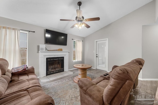 4546 Northpointe Pl, Pensacola, FL 32514 - living area with vaulted ceiling, a ceiling fan, a tiled fireplace, and baseboards