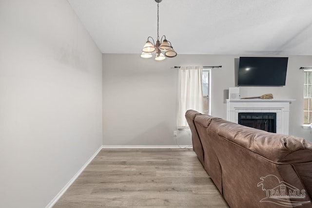 4546 Northpointe Pl, Pensacola, FL 32514 - living room featuring a fireplace, light wood-style flooring, a chandelier, and baseboards