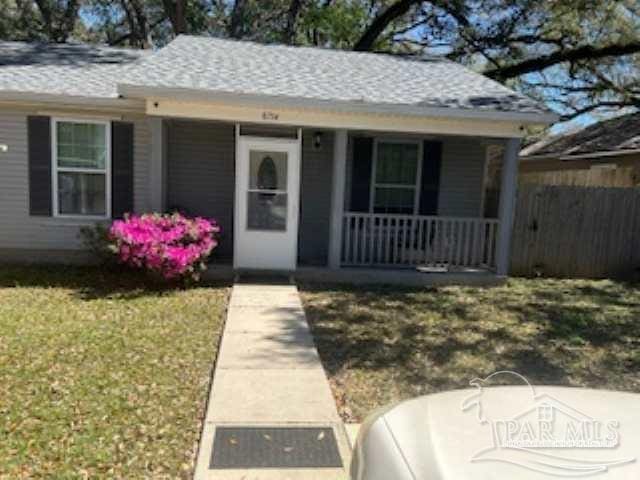 8714 Figland Ave, Pensacola, FL 32534 - view of front of house featuring a front lawn, fence, covered porch, and a shingled roof