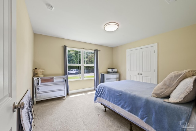 carpeted bedroom featuring a closet and baseboards