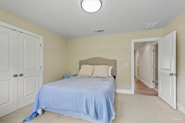 carpeted bedroom featuring baseboards and a closet