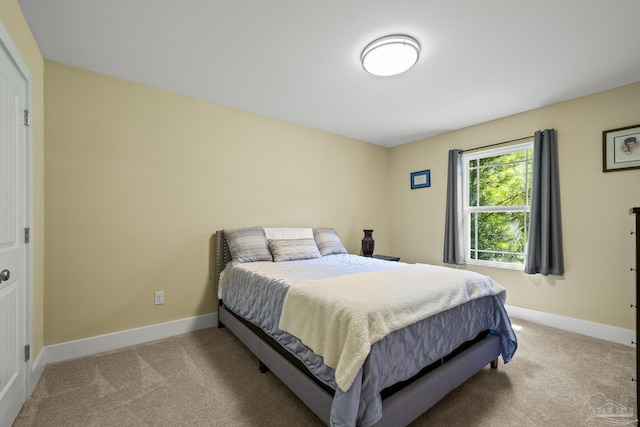 bedroom with light colored carpet and baseboards