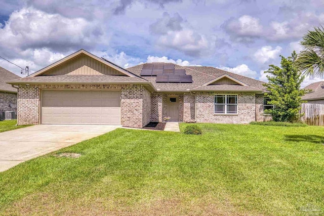 single story home featuring roof mounted solar panels, concrete driveway, a garage, roof with shingles, and brick siding