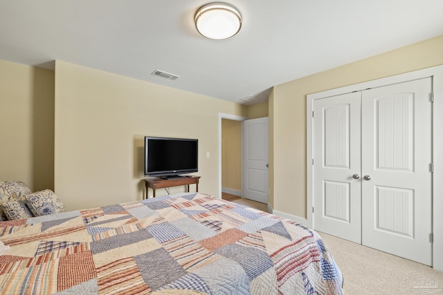 bedroom with light carpet, a closet, and baseboards