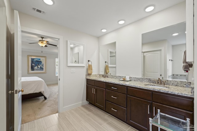 bathroom with a ceiling fan, baseboards, double vanity, ensuite bath, and recessed lighting