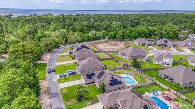 aerial view of residential area with a pool area and a large body of water