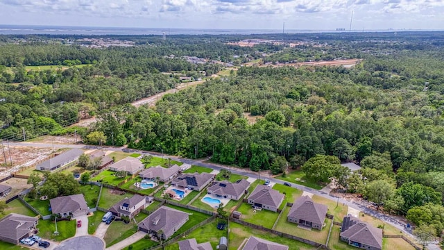 aerial view of property and surrounding area with a forest and nearby suburban area