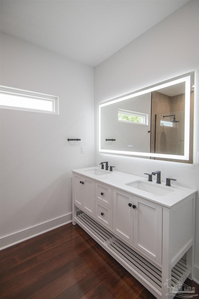 502 W Gregory St, Pensacola, FL 32502 - bathroom with wood finished floors, double vanity, baseboards, and a shower