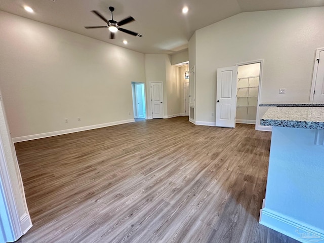 unfurnished living room featuring hardwood / wood-style flooring, high vaulted ceiling, and ceiling fan