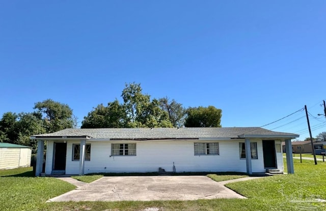 rear view of property featuring a patio and a yard