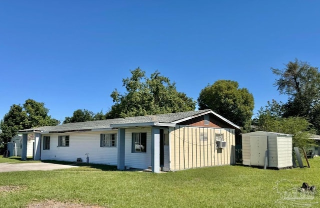 view of front of property with a front yard and a storage shed