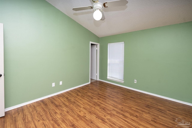 empty room featuring a textured ceiling, vaulted ceiling, hardwood / wood-style floors, and ceiling fan