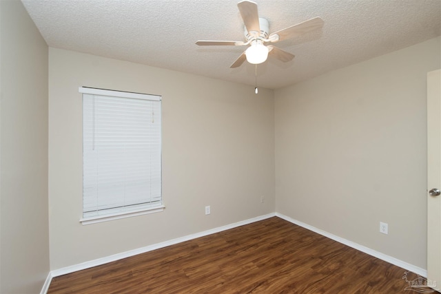 empty room featuring ceiling fan, dark wood-type flooring, and a textured ceiling