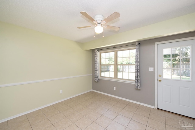 tiled foyer entrance featuring ceiling fan and a textured ceiling