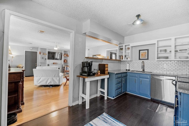 kitchen featuring stainless steel dishwasher, a sink, blue cabinets, and open shelves