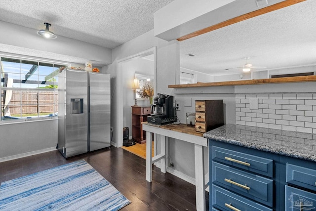 kitchen with dark wood finished floors, a textured ceiling, blue cabinetry, stainless steel fridge, and backsplash