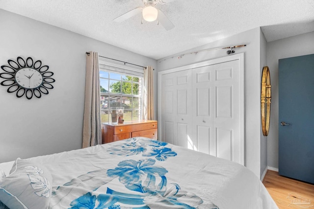 bedroom with light wood finished floors, a closet, a textured ceiling, and ceiling fan