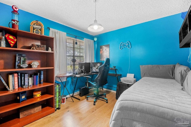 bedroom with wood finished floors and a textured ceiling