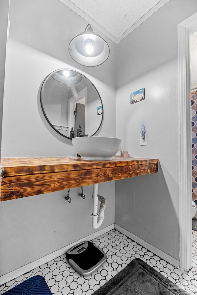 bathroom with a sink, tile patterned floors, and baseboards