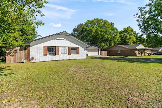 view of front of home featuring brick siding, a front lawn, fence, and a garage