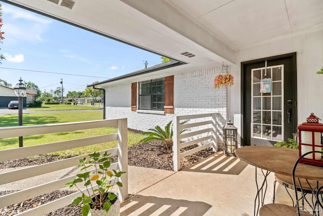 entrance to property with brick siding and a yard