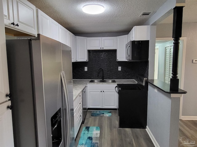 kitchen with white cabinets, kitchen peninsula, sink, and appliances with stainless steel finishes