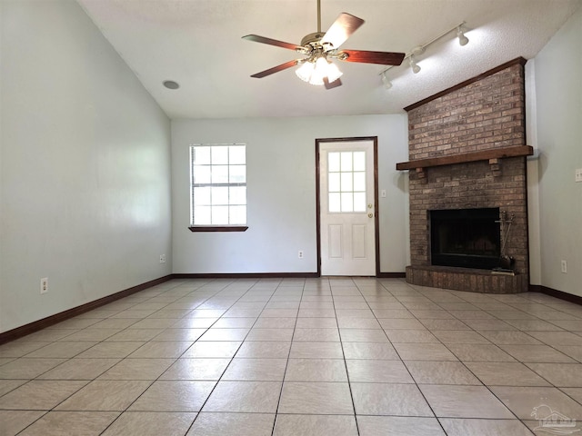 1900 W Kingsfield Rd, Cantonment, FL 32533 - unfurnished living room with vaulted ceiling, rail lighting, a ceiling fan, light tile patterned flooring, and a brick fireplace