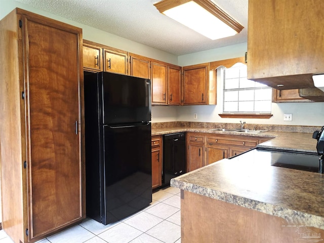 1900 W Kingsfield Rd, Cantonment, FL 32533 - kitchen featuring black appliances, brown cabinetry, light tile patterned floors, and a textured ceiling