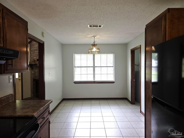 1900 W Kingsfield Rd, Cantonment, FL 32533 - unfurnished dining area featuring a textured ceiling, a fireplace, and light tile patterned flooring