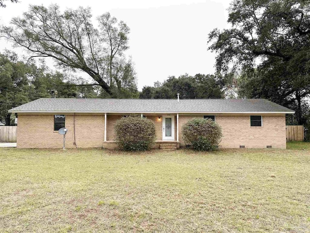 back of property featuring crawl space, fence, a lawn, and brick siding